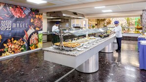 Un buffet proposant une variété de plats et un chef qui prépare les aliments.