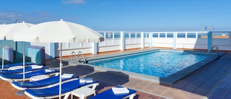 Piscine extérieure, parasols de plage, chaises longues