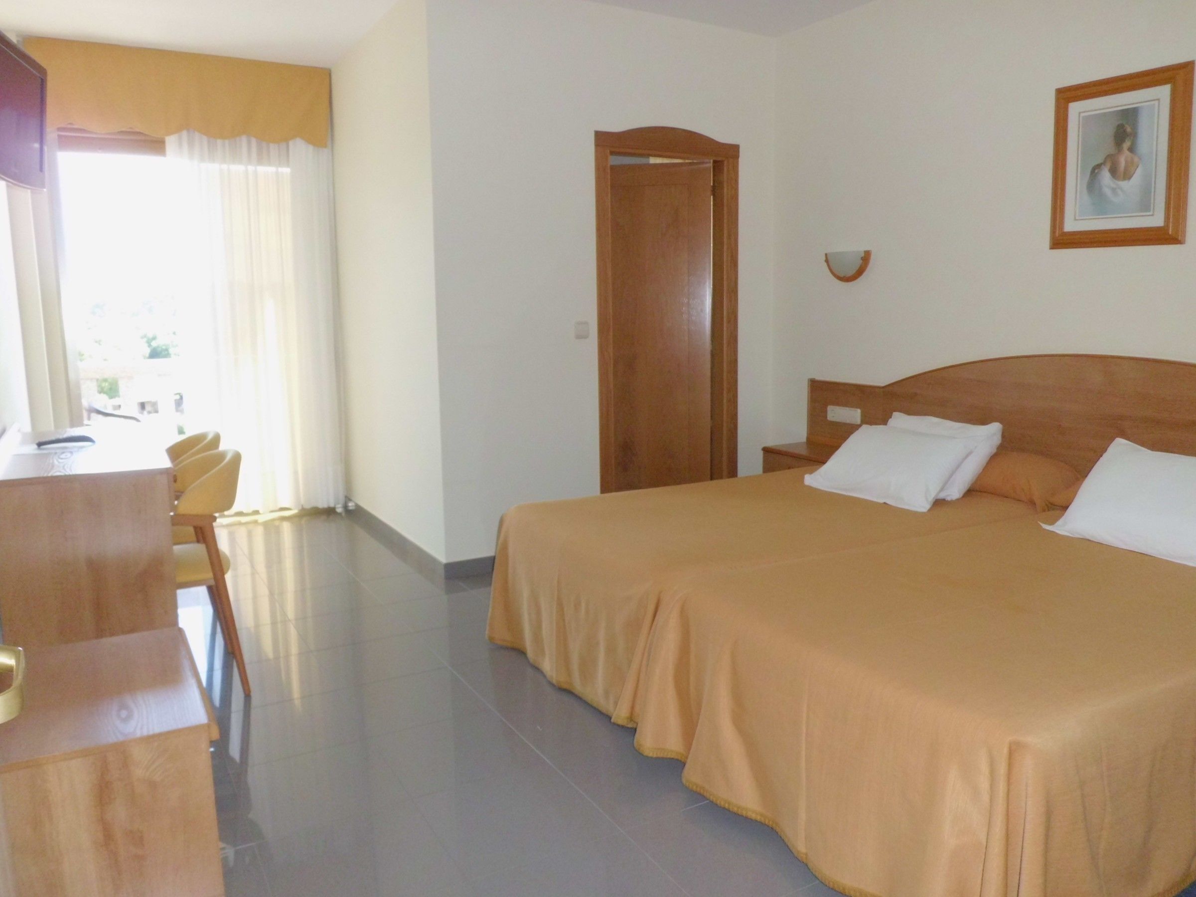Habitació d'hotel amb un llit, una taula i una cadira.