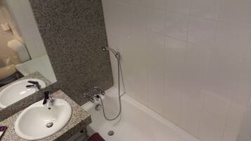 Une salle de bain avec deux lavabos, un miroir et une douche.
