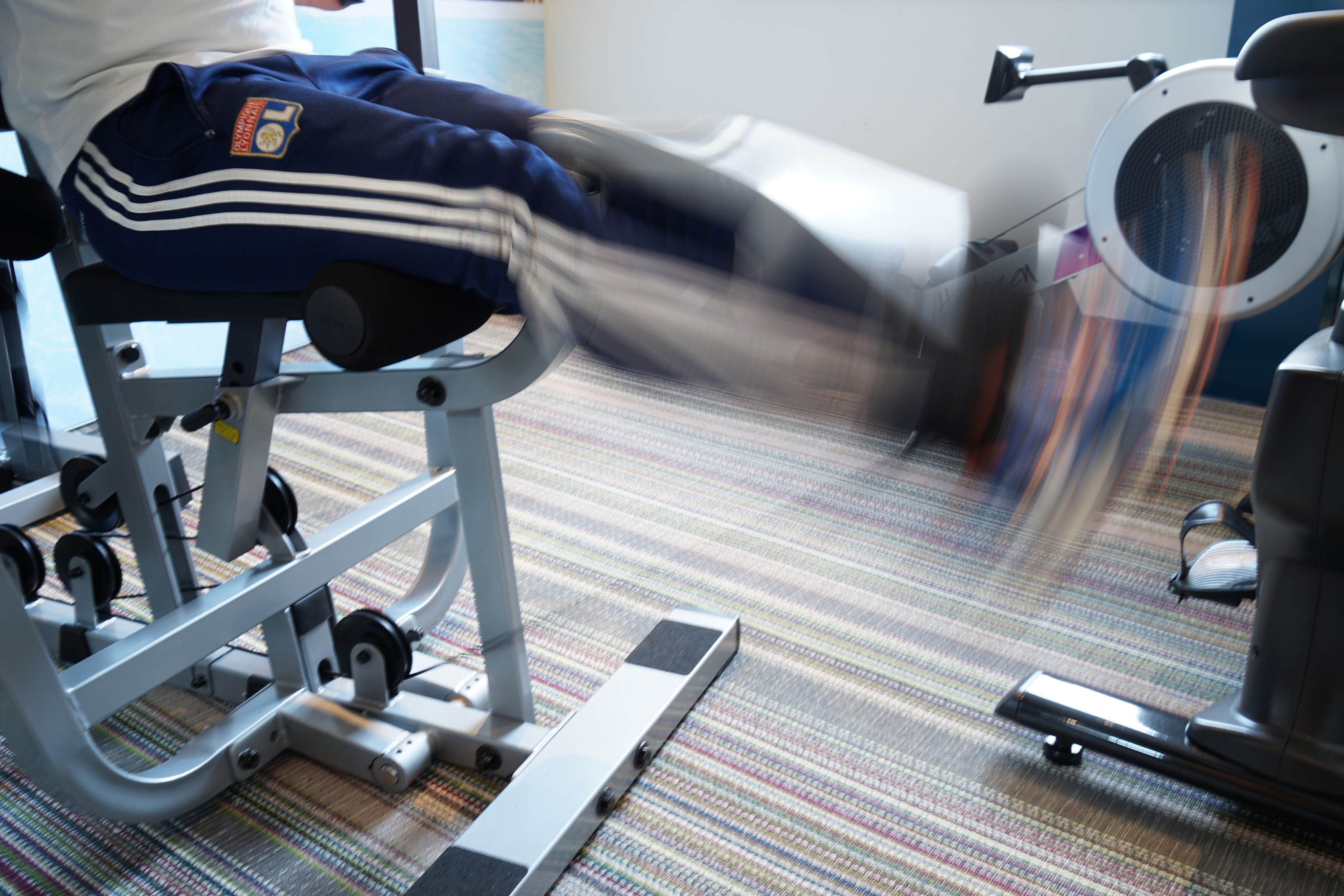 Een stilstaande trainingsmachine met een voetpedaal, een gewichtsstapel en een zitplaats.