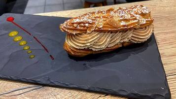 A dessert on a slate plate with a wooden table.