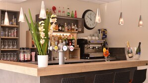A bar area with a counter, seating, and various bottles and glasses.