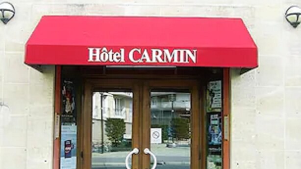 A hotel entrance with a red awning and double doors. - Hotel Carmin (Le Havre)
