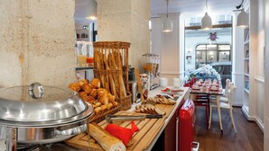 Montaje tipo buffet con diversos alimentos y un área de comedor con sillas y una mesa.