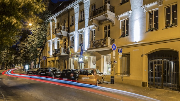 A multi-story building with balconies, a parking area, and a gated entrance. - IVOLITA Vilnius Hotel (Vilnius)