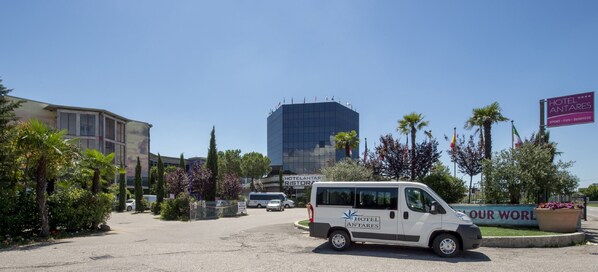 A white van parked in front of a building with a sign reading "Hotel Antares" and "Our World". - Hotel Antares (Villafranca di Verona)