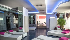 A modern lounge area with white wicker sofas, pink cushions, and a large potted plant. - Hotel Antares (Villafranca di Verona)