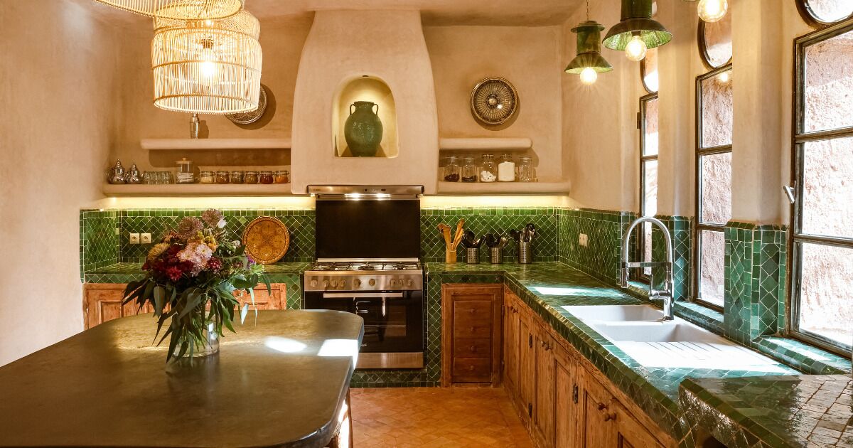 Una cocina con una isla central, estufa y lavamanos.