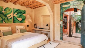 A bedroom with a bed, a desk, and a view of the outside. - Le Jardin Des Douars (Aguerd)
