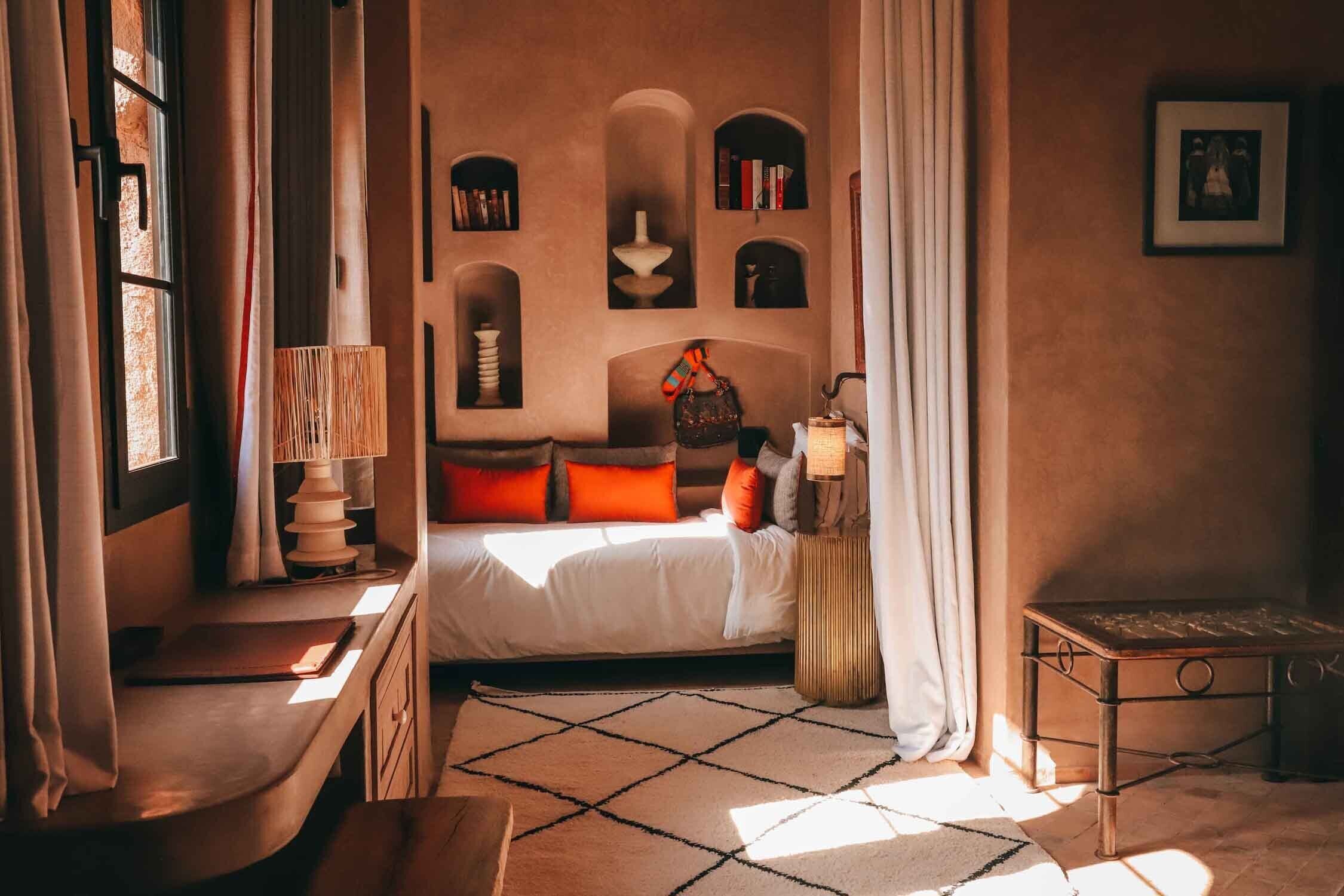 Una camera da letto accogliente con un letto, comodini, una lampada e una finestra con tende.