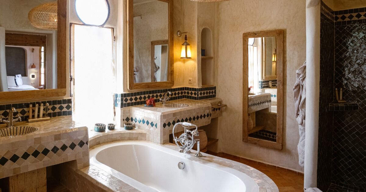 A bathroom with a large bathtub, two sinks, and multiple mirrors.