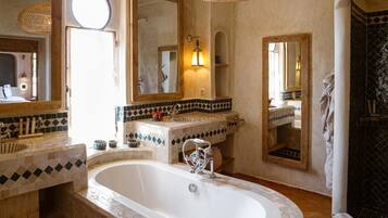 A bathroom with a large bathtub, two sinks, and multiple mirrors.