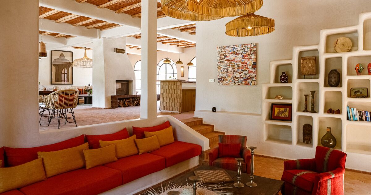 A spacious living area with a red sofa, a coffee table, and a bookshelf.
