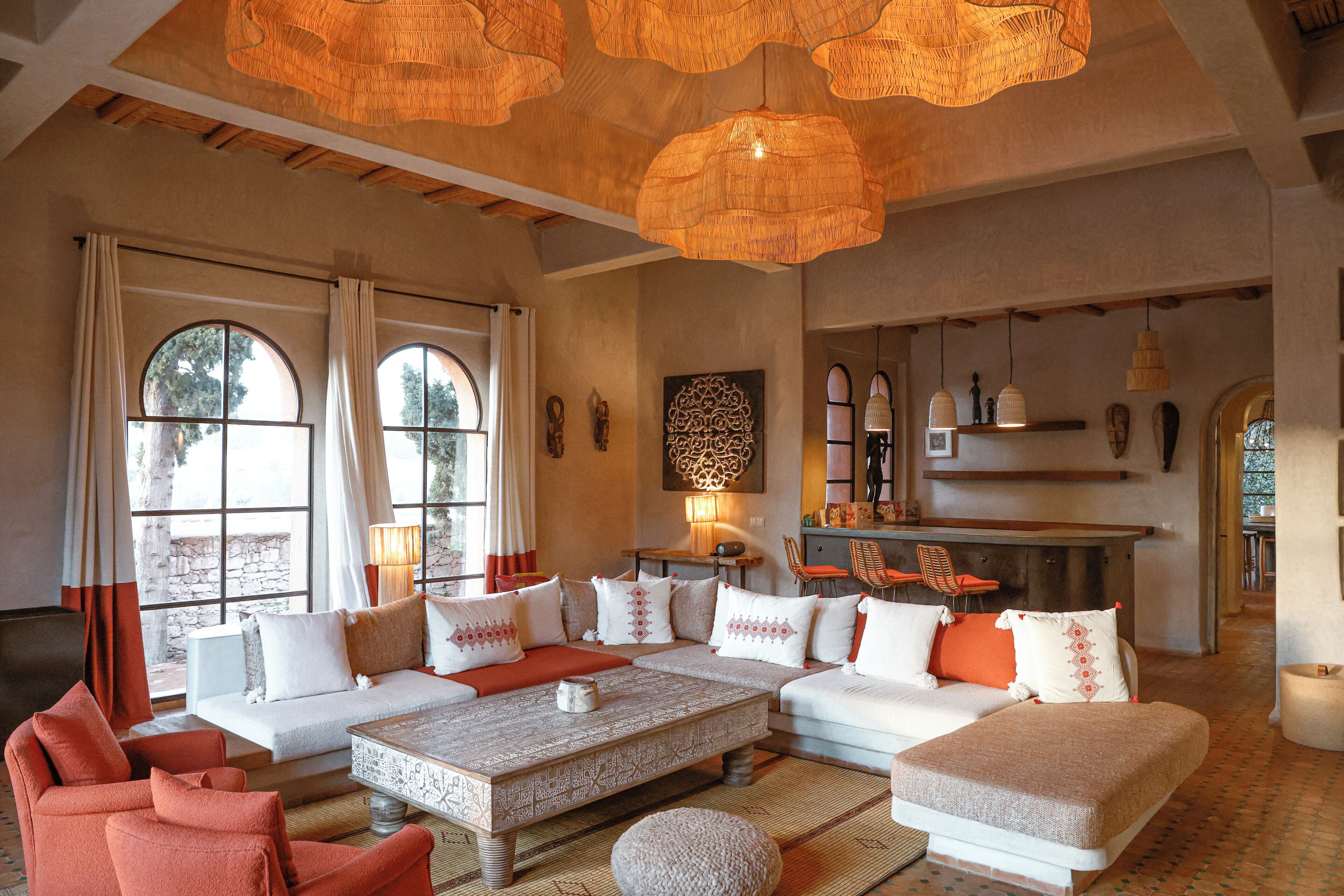 A spacious living room with a large sofa, a coffee table, and a dining area with chairs.
