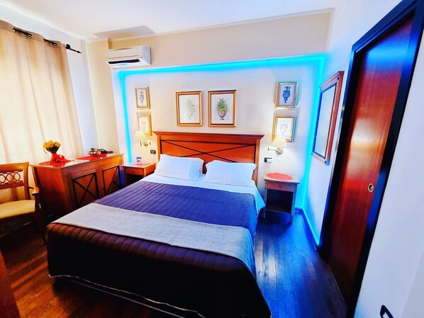 A hotel room with a large bed, bedside tables, a desk, and a chair. - Hotel Florio Operà Palermo Central (Palermo)