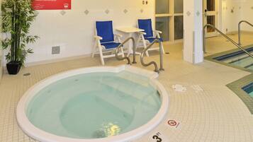 An indoor swimming pool with a lifeguard chair, a blue chair, and a sign indicating a depth of 3 feet.