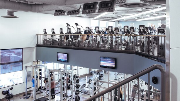 A multi-level gym with treadmills, weight machines, and a mezzanine with exercise equipment. - Holiday Inn Express Hotel & Suites Edmonton North by IHG (Edmonton)