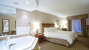 A hotel room with a large bed, a separate bathroom with a bathtub, and a small seating area. - Holiday Inn Express Hotel & Suites Edmonton North by IHG (Edmonton)