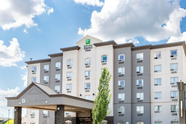 Un bâtiment de la chaîne Holiday Inn Express, doté d’un design moderne, avec une entrée imposante et de nombreuses fenêtres.
