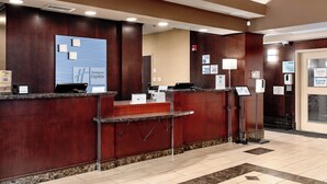 A hotel reception desk with a digital screen displaying the hotel name, a check-in counter, a quiet hours sign, and a pool sign. - Holiday Inn Express Hotel & Suites Edmonton North by IHG (Edmonton)
