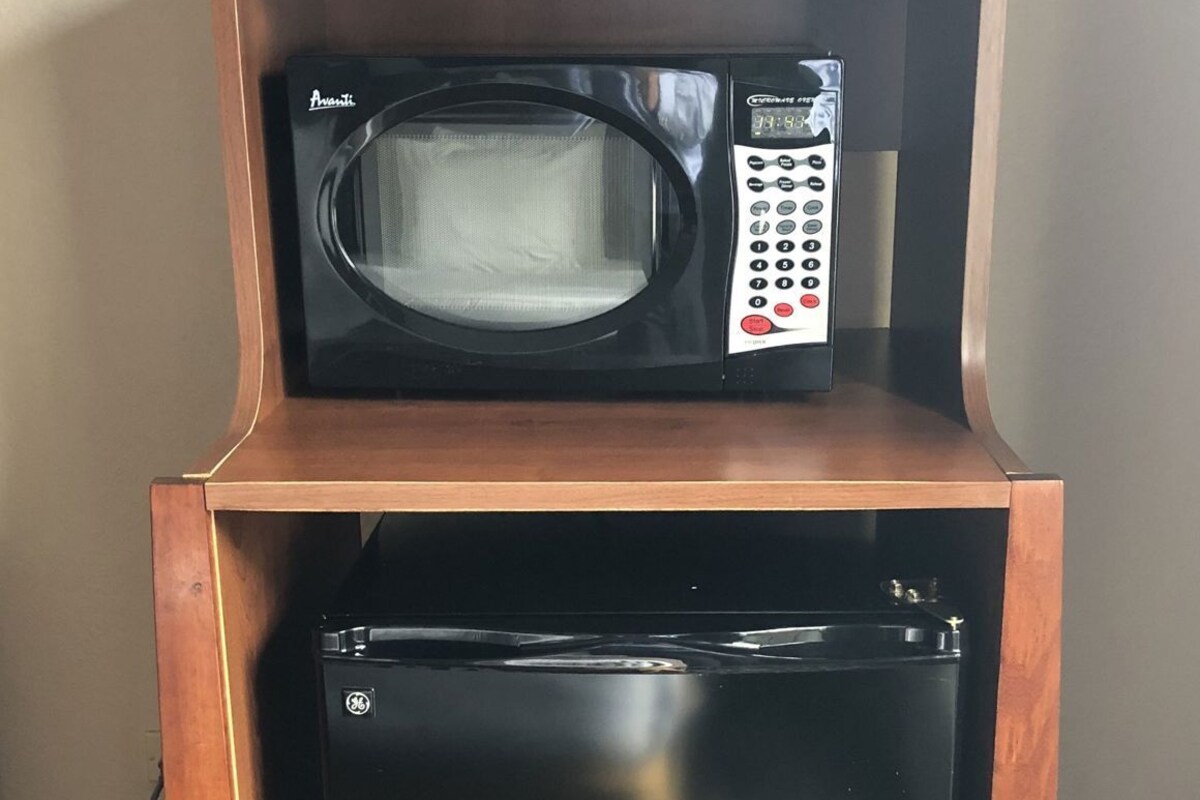 A compact kitchenette with a microwave and a small refrigerator.