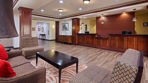 Un hall con recepción, zona de estar y estación de café.