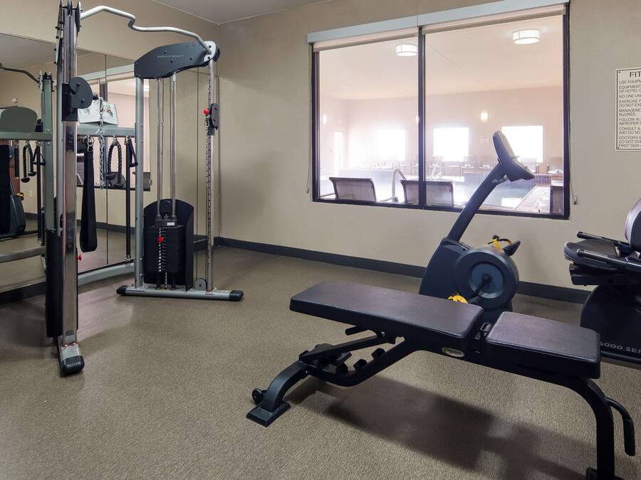 A fitness center with exercise equipment, a treadmill, and a mirrored wall.