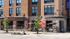 A multi-story building with a restaurant named 'Bar & Grill' on the ground floor. - Hilton Garden Inn Bloomington (Bloomington)