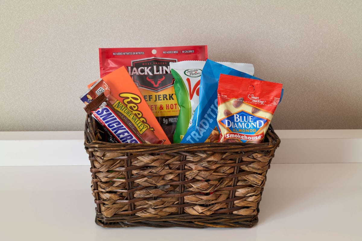 A wicker basket containing various snack items.