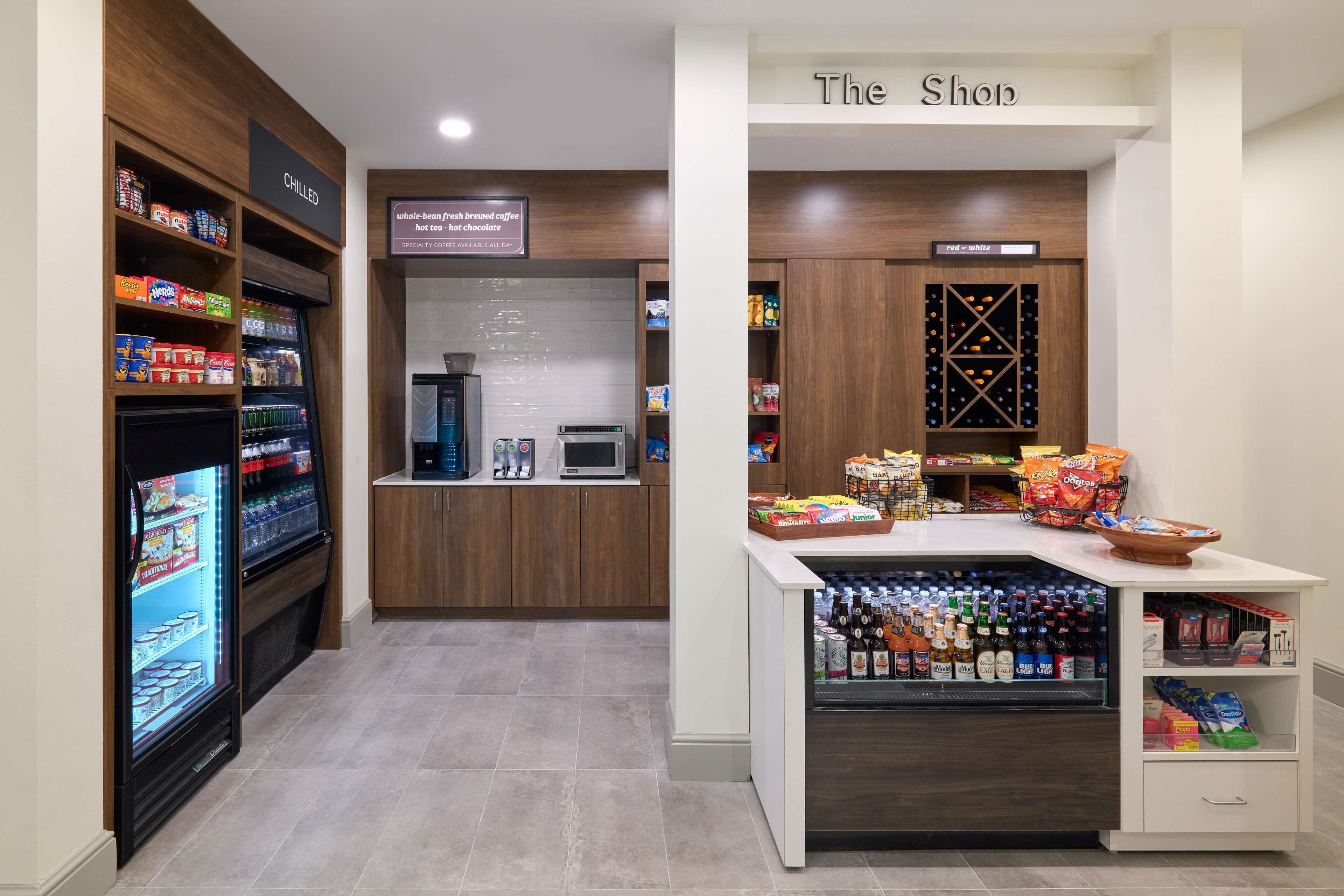 Een winkel met bewaarde snacks, een koffieapparaat en een wijnrek.