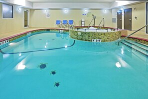 An indoor swimming pool with a tiled edge, a hot tub, and a lifeguard chair. - Holiday Inn Express & Suites Woodward by IHG (Woodward)