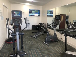 A hotel fitness center with cardio machines, free weights, and a mirrored wall. - Holiday Inn Express & Suites Woodward by IHG (Woodward)