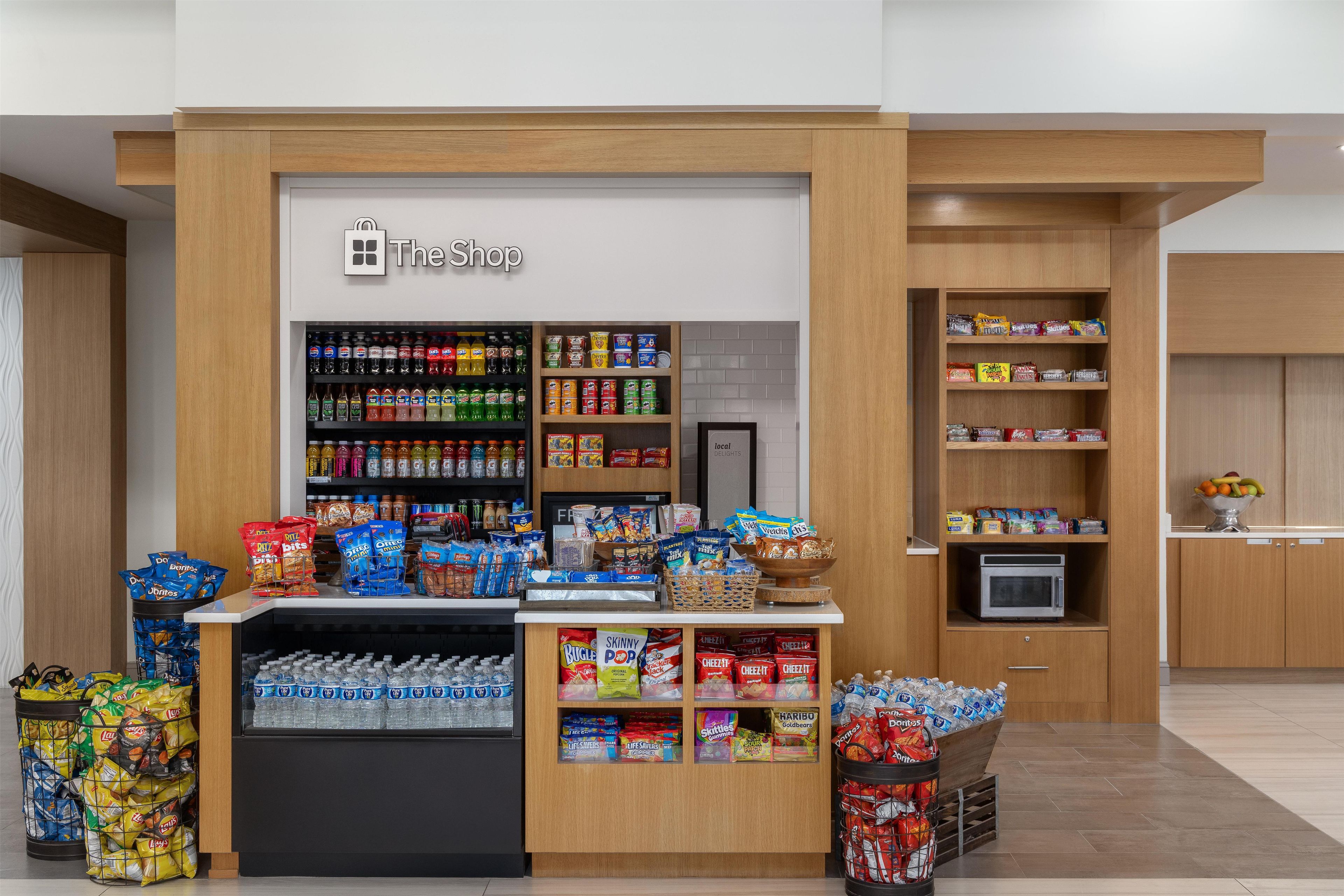 A The Shop kiosk with a variety of snacks, beverages, and a microwave.