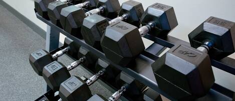 A rack of hexagonal dumbbells with weight markings.