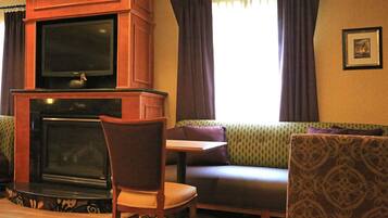 A living room with a fireplace, a television, a sofa, and a chair.