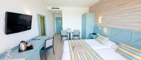 A hotel room with a bed, a desk, a TV, and a small table.