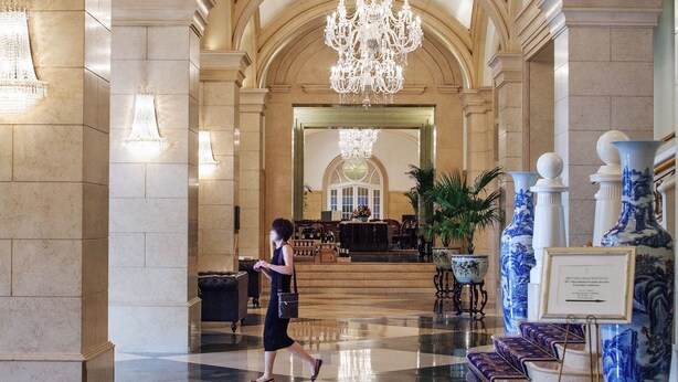 A grand lobby with a large chandelier, marble columns, and a checkered floor. - Beijing Hotel Nuo Forbidden City (Beijing)