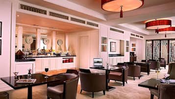 A spacious hotel lobby with a central bar area, multiple seating arrangements, and a modern design.