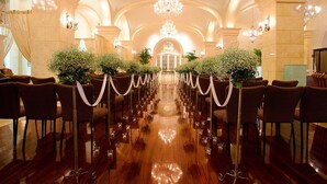 A grand hall with rows of chairs, a chandelier, and a polished wooden floor. - Beijing Hotel Nuo Forbidden City (Beijing)