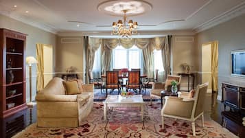 A spacious living room with a chandelier, a coffee table, and a television.