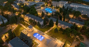 Una piscina al aire libre, sombrillas, sillones reclinables de piscina