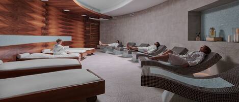 A spa room with wooden paneling, a large skylight, and multiple massage tables.