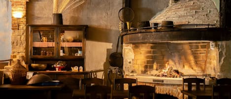 Une pièce chaleureuse avec une cheminée, des meubles en bois et une nappe à carreaux.
