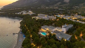 An aerial view of a coastal hotel with multiple buildings, a swimming pool, and a beach. - Bluesun Hotel Borak (Bol)