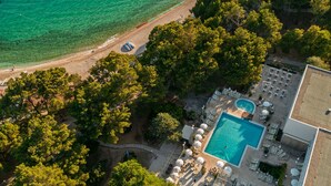 An aerial view of a resort with a swimming pool, lounge chairs, and a beach area. - Bluesun Hotel Borak (Bol)