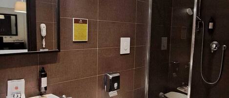 A modern bathroom with a sink, bidet, toilet, and a glass-enclosed shower area.