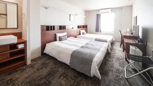 A hotel room with two beds, a desk, a chair, a small shelf with towels, and a window with curtains. - Vessel Hotel Fukuoka Kaizuka (Fukuoka)