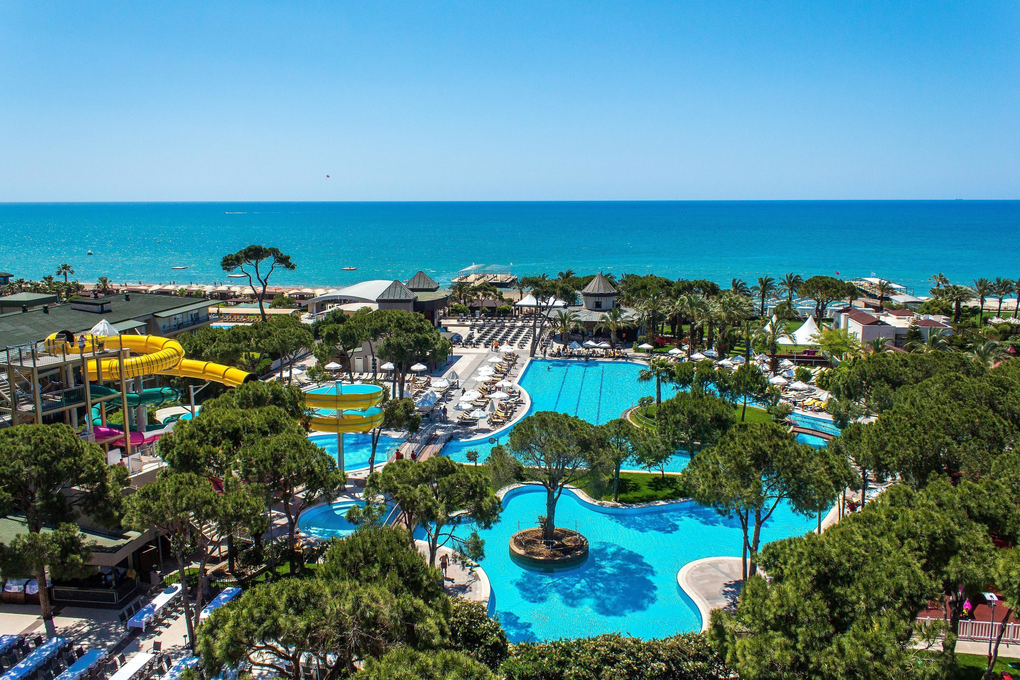 Un resort con múltiples piscinas, parque acuático y vistas al océano.