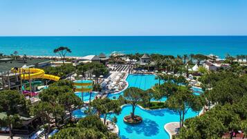 Un resort con múltiples piscinas, parque acuático y vistas al océano.
